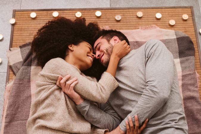 Multiethnic couple kissing on floor