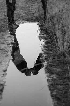 Men kissing near dog and water puddle