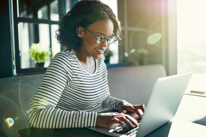 Happy woman working at laptop in cafe