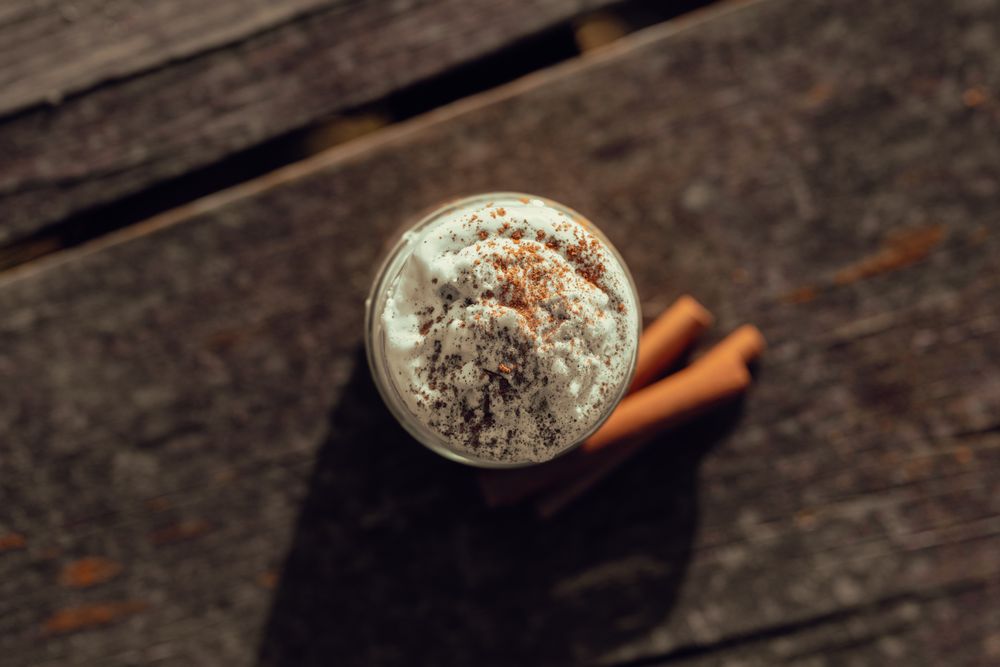 Cinnamon near coffee on table