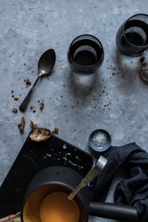 Glasses and spoons near pumpkin cream soup