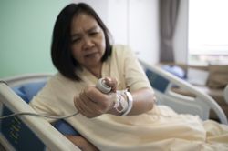 Asian female patient recovering from illness in hospital room, health care concept.