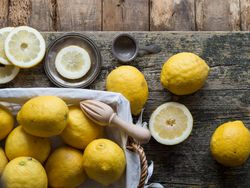 Lemons and reamer placed on wooden board