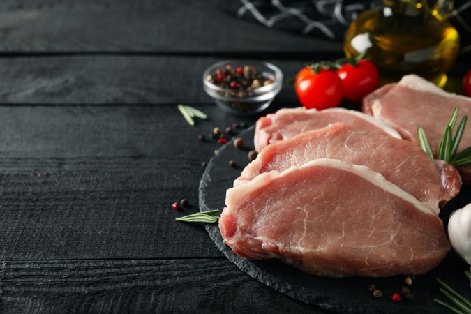 Composition with raw meat for steak and ingredients on wooden background