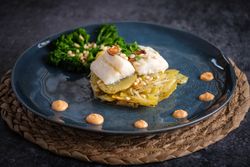 Appetizing gratin with fish served with sauce and broccoli