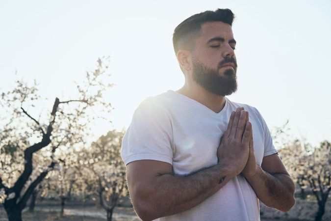 Bearded man meditating in spring garden