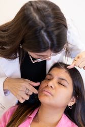 Beautician doing eyebrow threading design procedure
