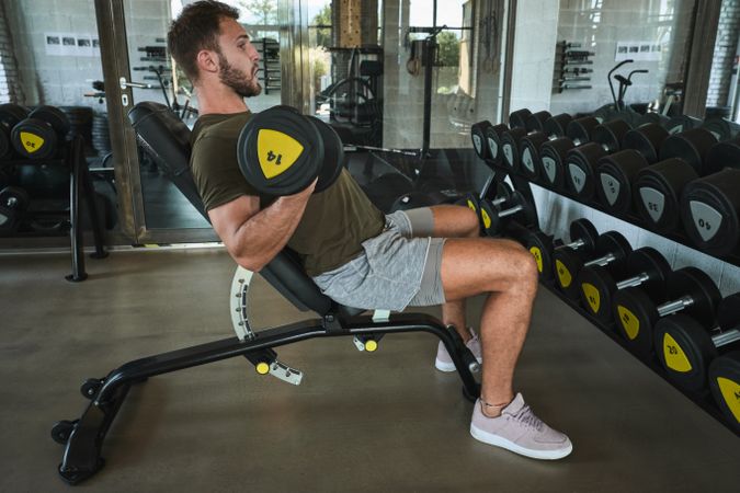 Strong man exercising with dumbbells in gym