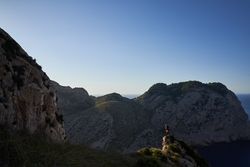 Unrecognizable traveler standing on mountain peak