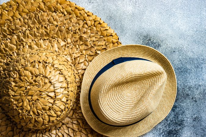 Top view of straw hats on grey table