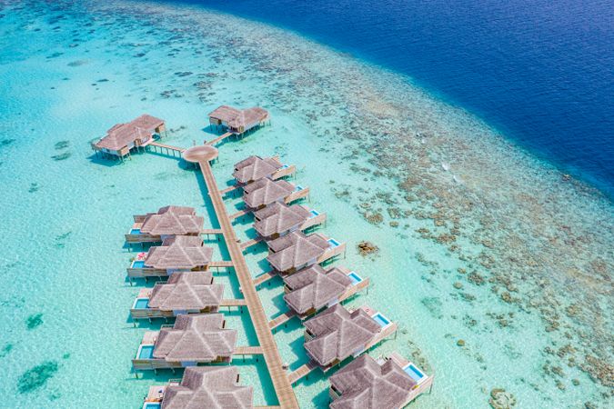 Drone shot of two rows of overwater bungalows in the Maldives