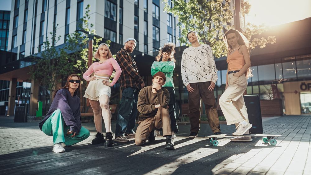 Vibrant Group Of Young Adults Showcasing Diverse Street Styles And Dynamic Poses