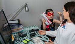 Woman working from home with her daughter interrupting her
