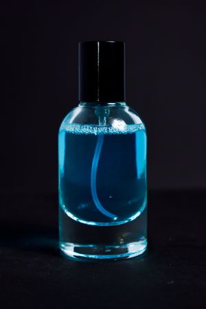 Light blue perfume bottle in studio shoot