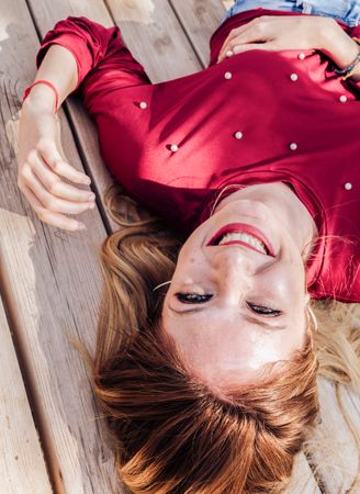 Smiling woman laying down on picnic table