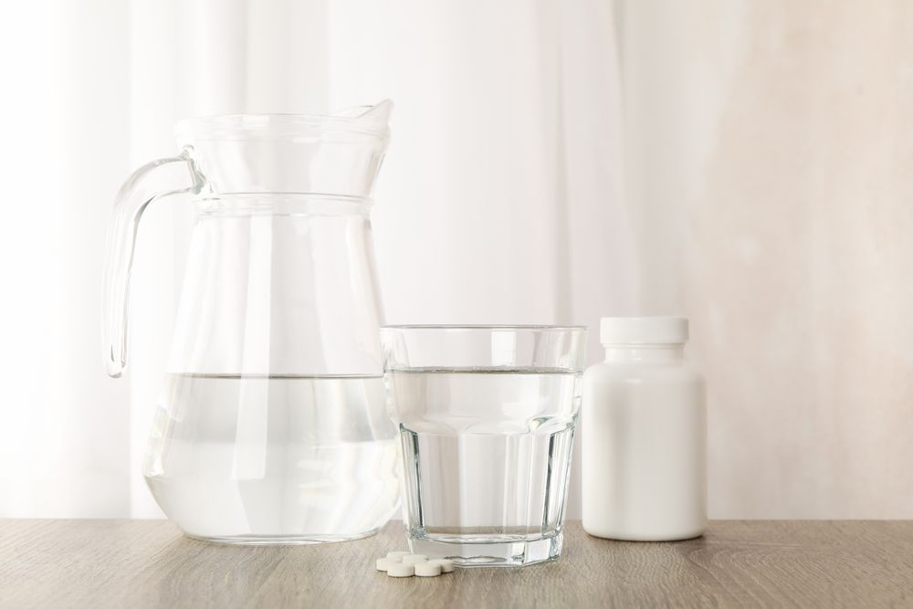 Pitcher and glasses by window
