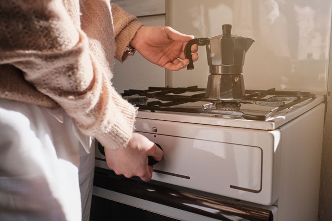 Unrecognizable person preparing coffee in moka pot
