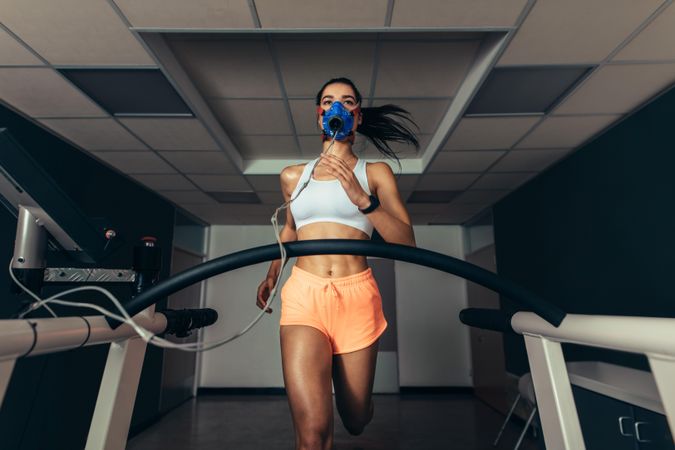 Athlete examining her performance in sports science lab running on treadmill