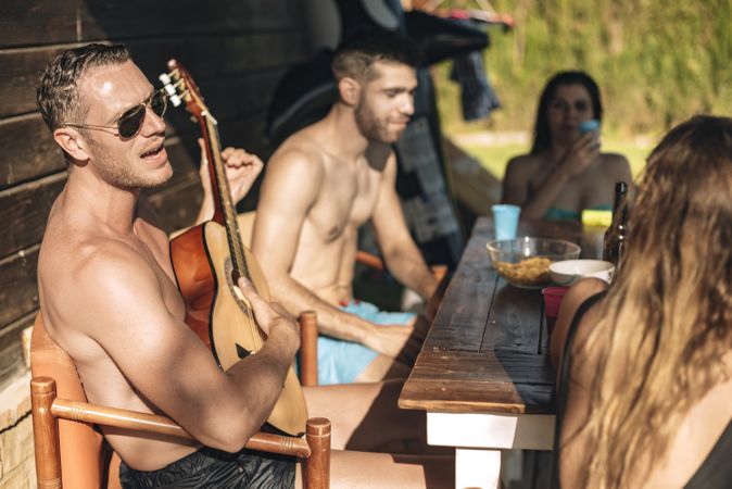 Friends playing guitar on porch