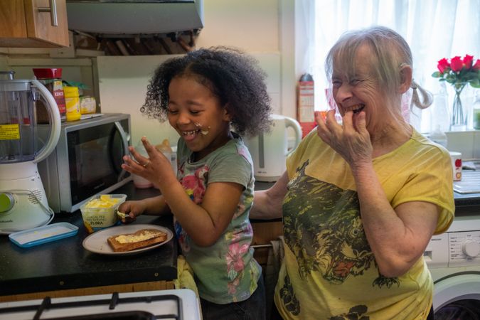 Older woman cooking with grandchild
