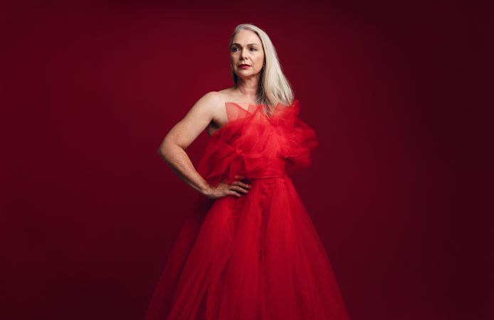 Woman in elegant red dress against red background
