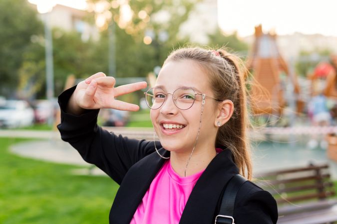 Girl making peace sign with her fingers.