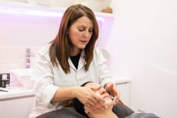 Beautician doing beauty massage on face of client in spa