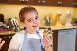 Smiling girl holding delicious cupcake
