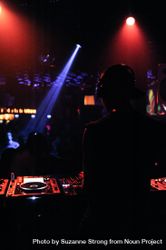 Back view of man DJing in dark club bG6KB4