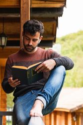 Pensive man chilling on terrace with book