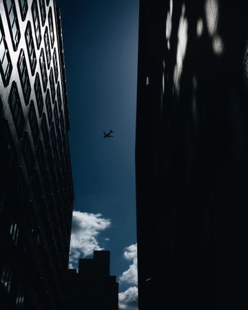 Low angle photography of airplane in mid air over high rise buildings in Imari, Saga, Japan