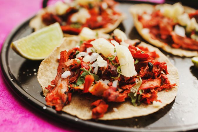 Pepper and lime near tacos al pastor and sauces