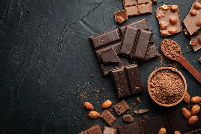 Chocolate, melted chocolate and almond on dark background