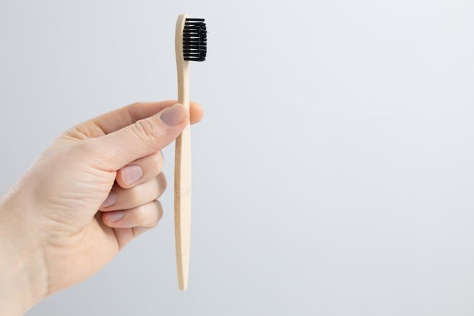 Man holding bamboo toothbrush