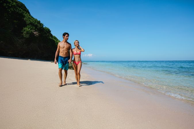 Romantic couple walking on tropical beach
