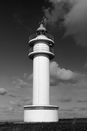Scenic view of lighthouse on coastline in cloudy day