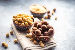 Bowls of whole blanched and unblanched hazelnuts on kitchen counter
