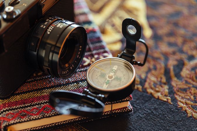 Retro photo camera and compass on book