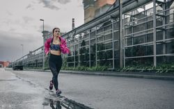Sportswoman running in an industrial zone