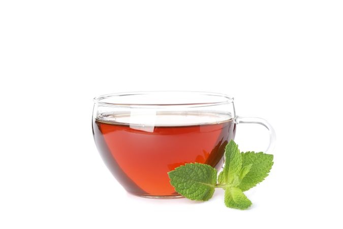 Cup of tea and mint leaf isolated on blank background