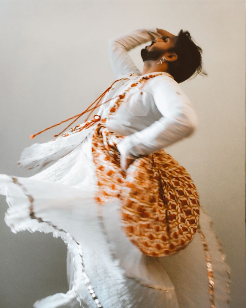 Indian man in kathak dress dancing for Tulsi Vivah