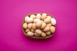 Eggs basket on pink background, top view