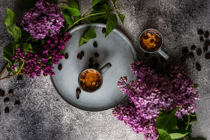 Top view of coffee and lilac flowers on concrete counter
