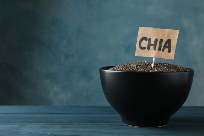 bowl and word Chia on wooden background, copy space