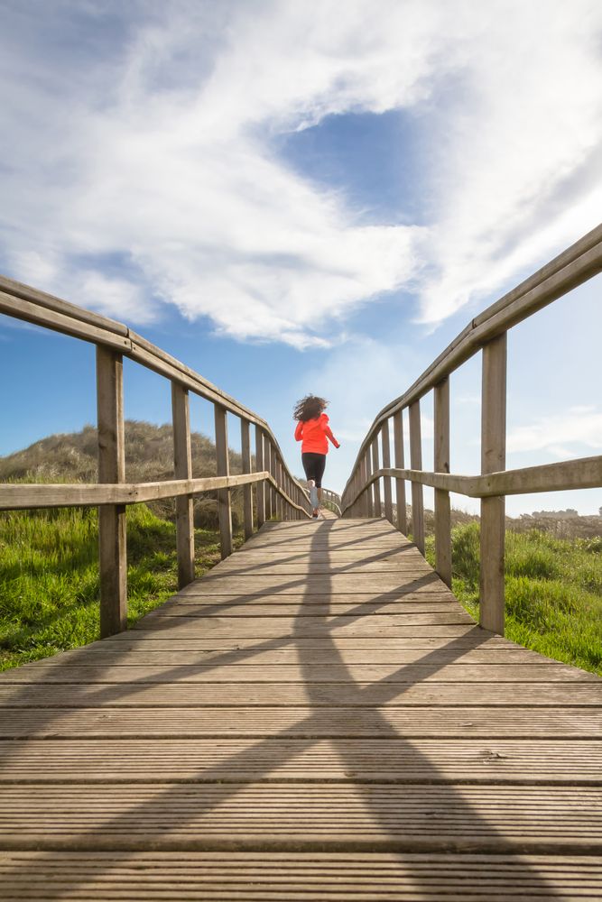 Woman running down wooden path
