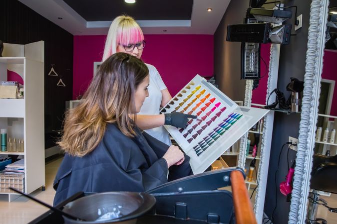 Hair stylist and client choosing hair color