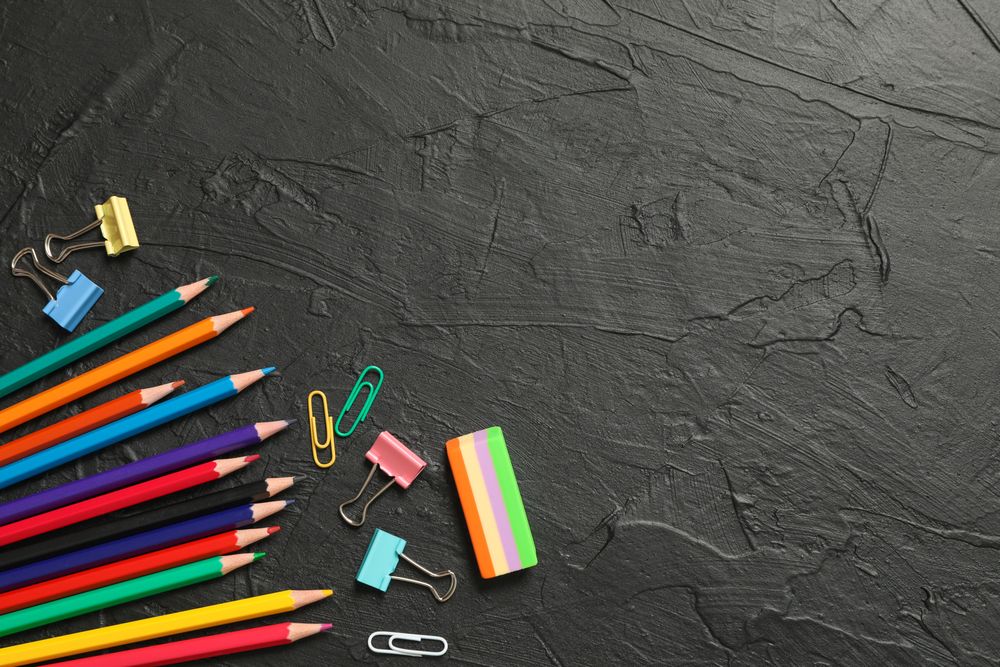 Composition with school supplies on dark background, space for text