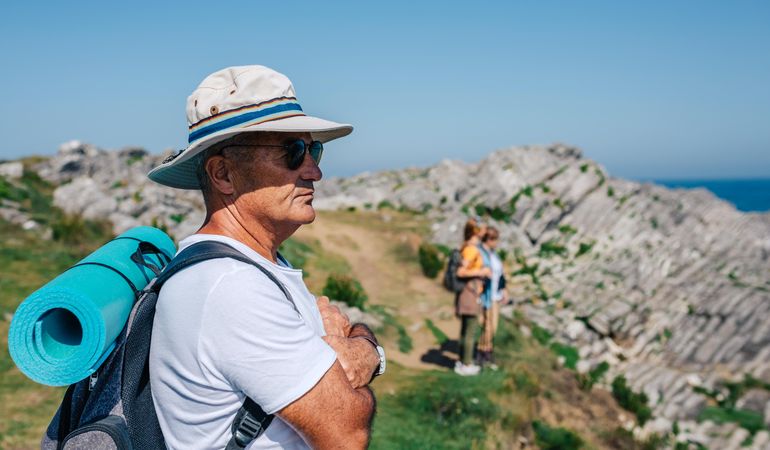 Older man in foreground of his hiking crew enjoying view
