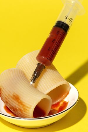 Stuffed pasta with red sauce in syringe