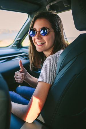 Woman doing thumbs up in the car